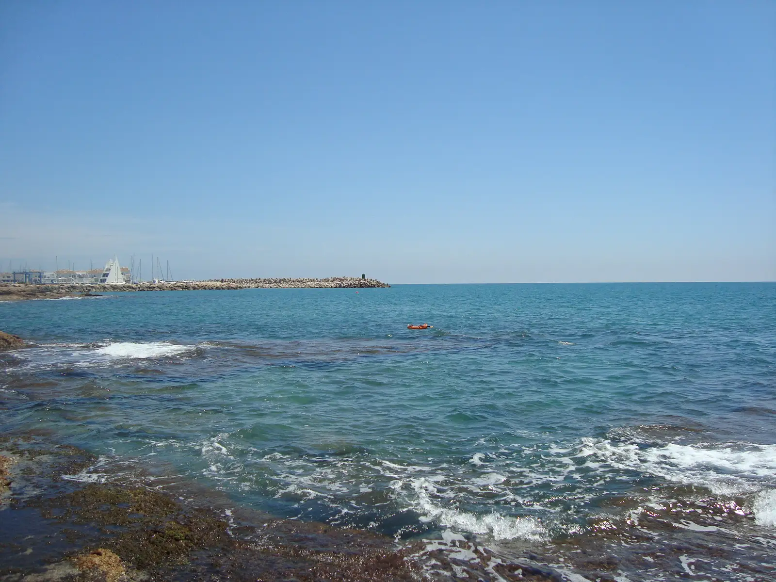 Costa rocosa de Alcossebre con el puerto deportivo al fondo, en la Costa del Azahar