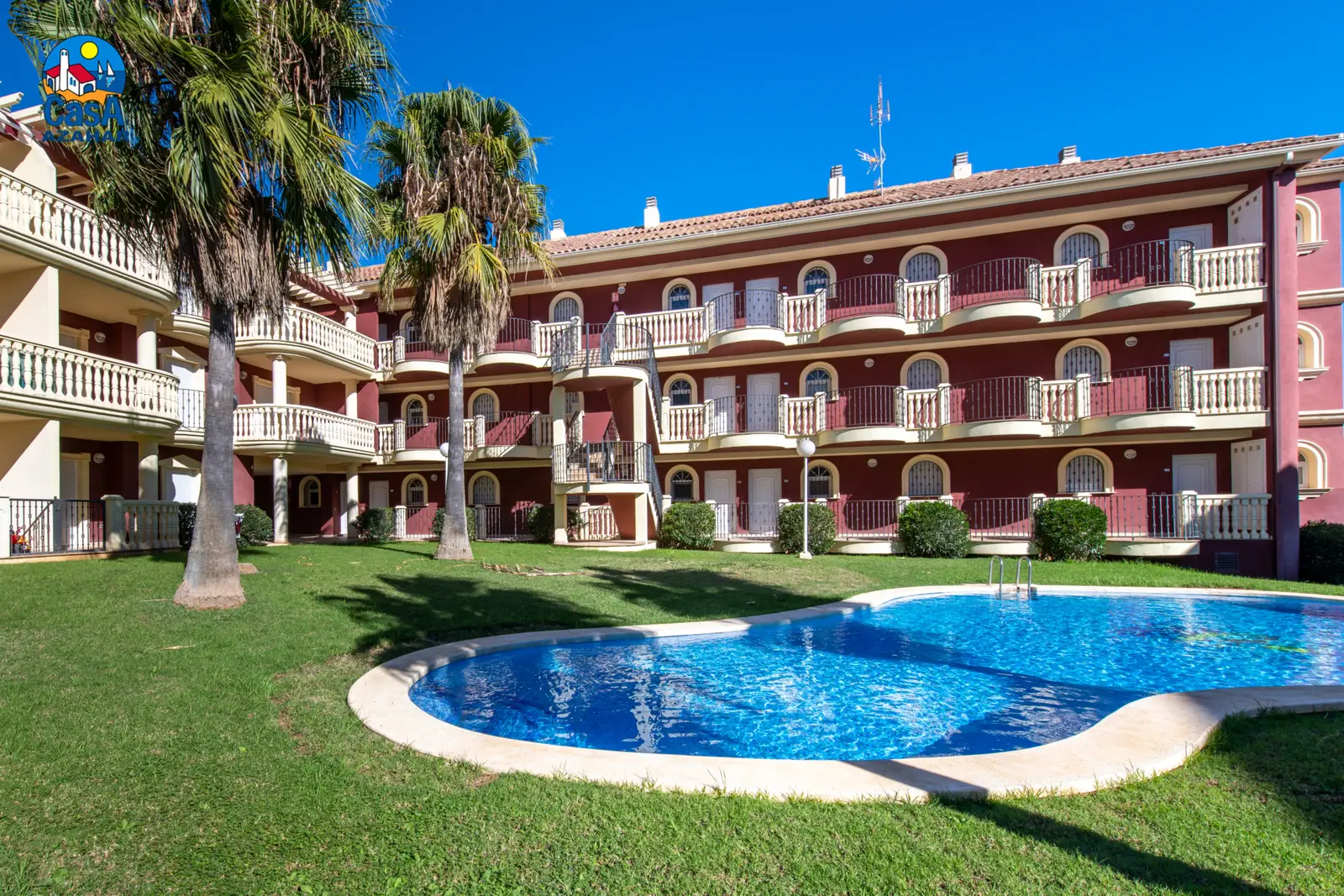 Piscine des appartements Madeira entourée de pelouse à Alcossebre